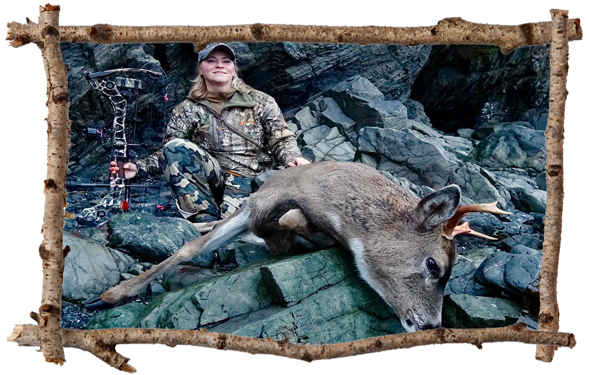 female hunter posing with a buck